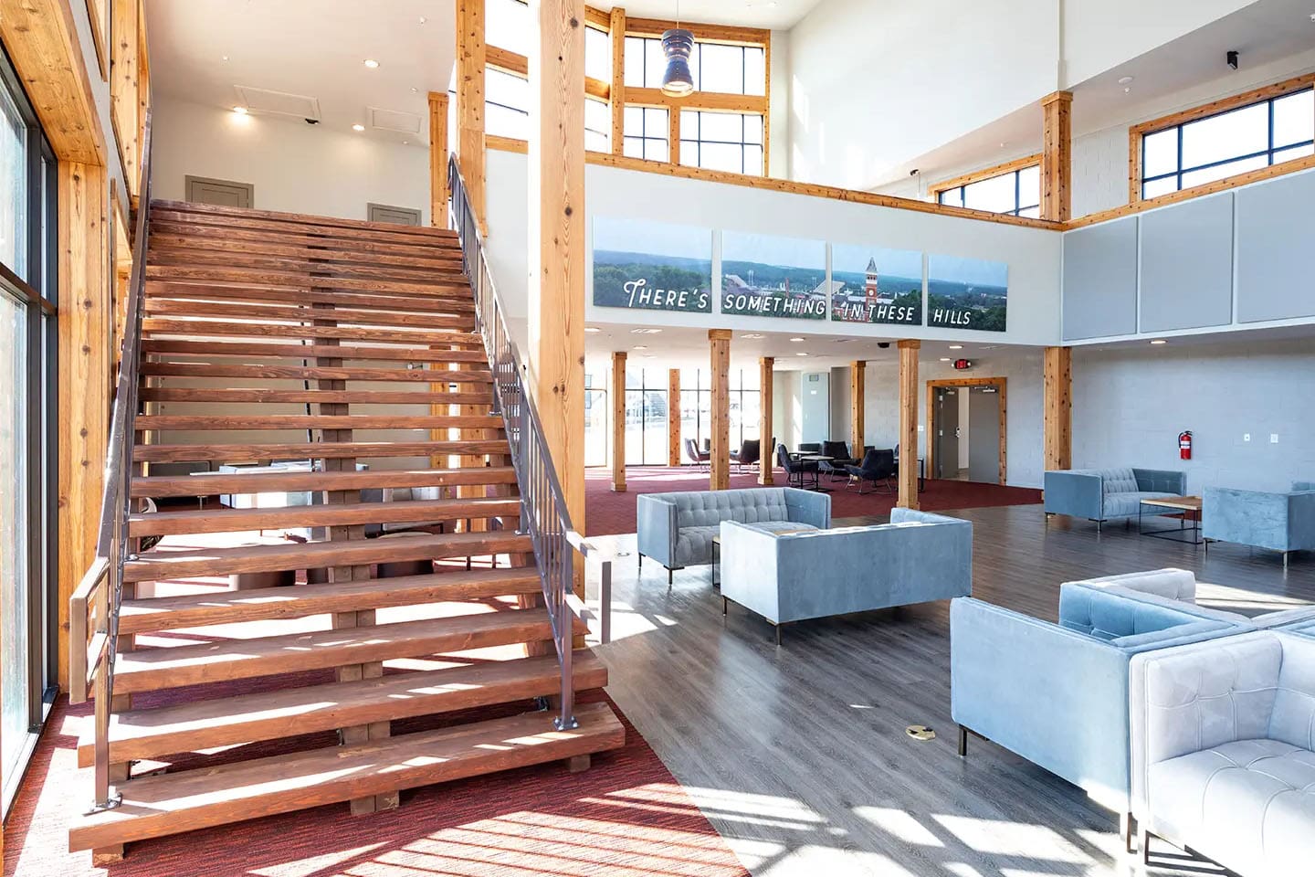 Open area with two floors and various seating options with bright light from windows.