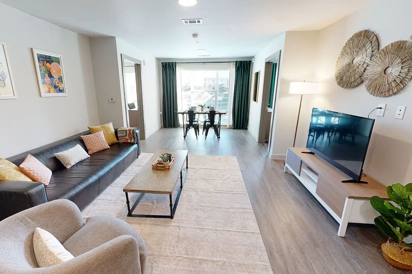 Large open apartment with seating, a coffee table, TV, and large window.